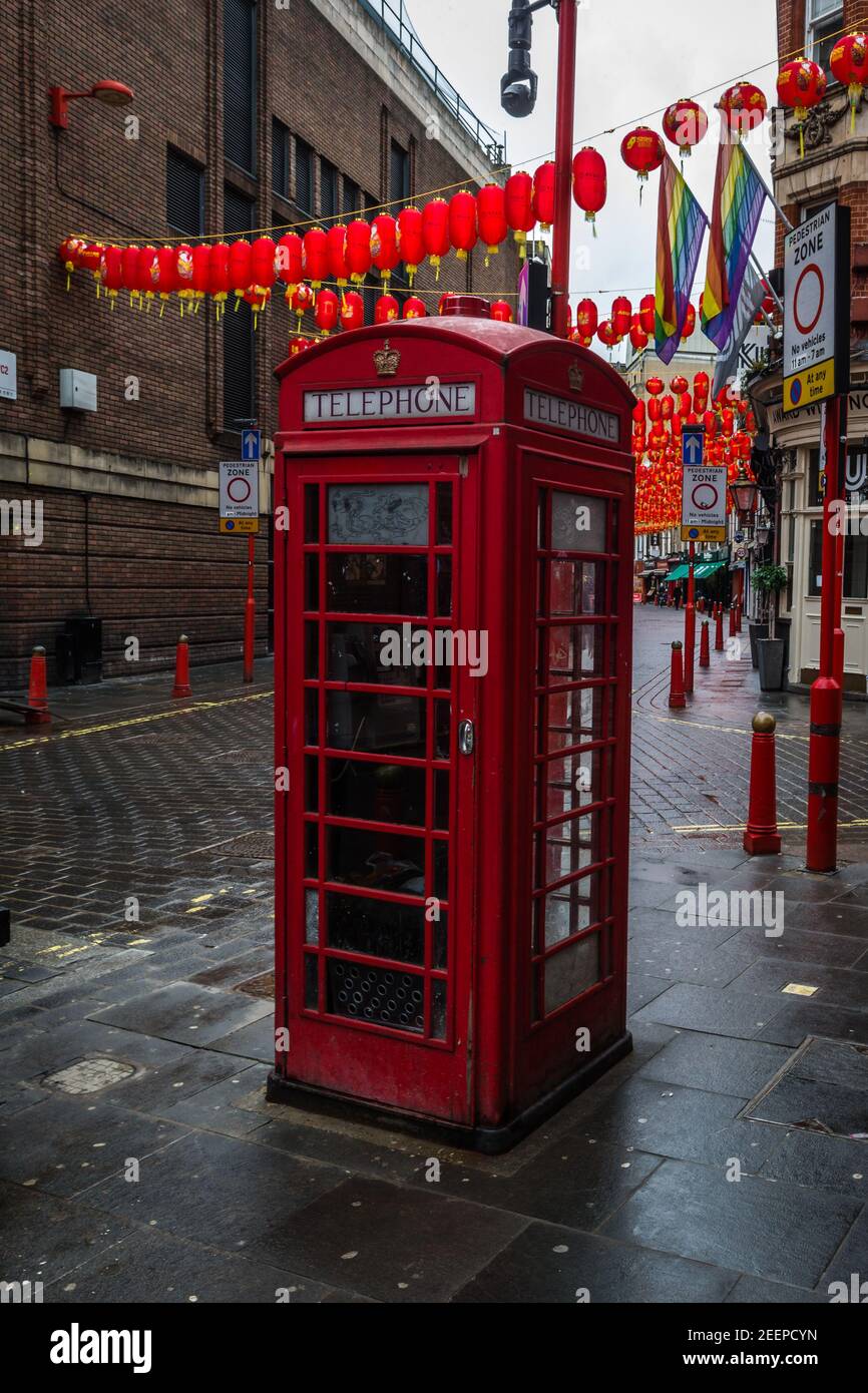 Chinese Lunar new year of the ox lanterns hang above a red telephone box in a deserted Chinatown in London during the lockdown. Stock Photo