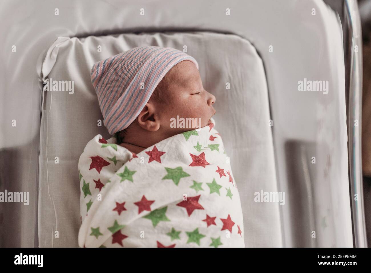 Newborn baby boy in bassinet wrapped in hospital blanket with hat Stock Photo