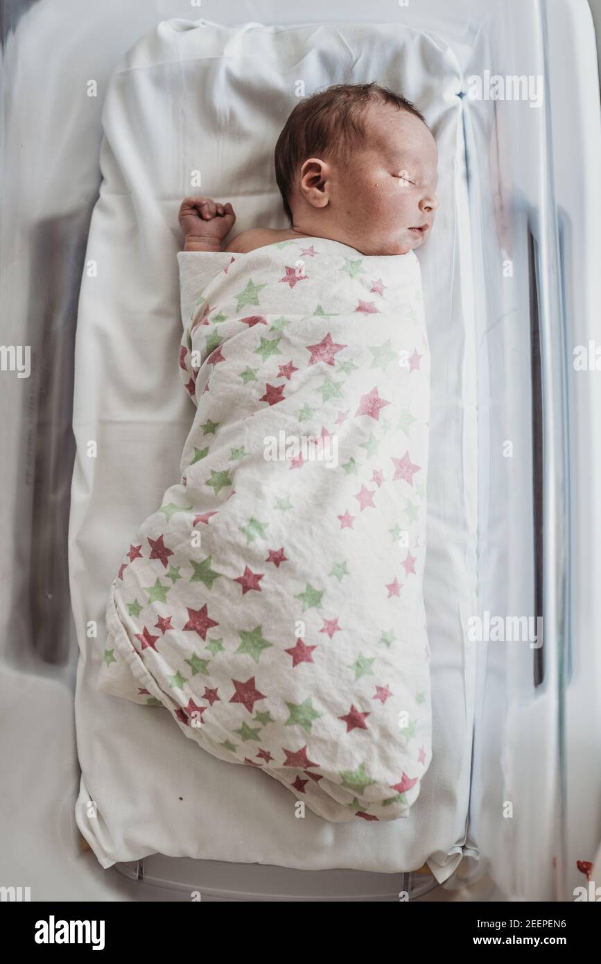 newborn baby boy in bassinet wrapped in hospital blanket Stock Photo
