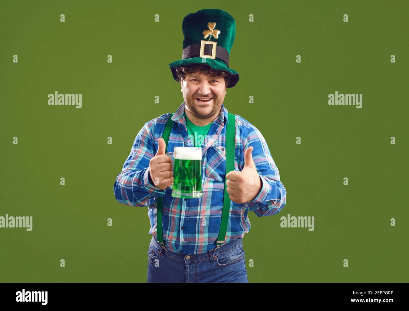 Positive man with green beer showing thumbs up during Patrick day Stock Photo