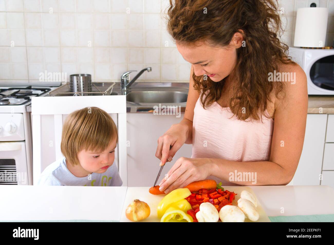 Single mother making dish for her son with Down Syndrome during Stock Photo
