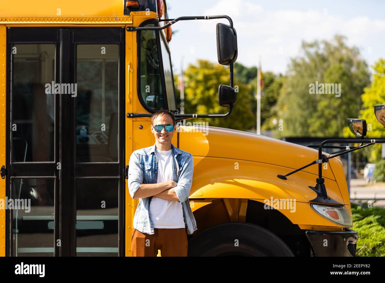 A happy male teacher near school bus Stock Photo - Alamy