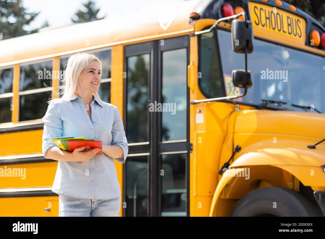 Teacher at school in front of the bus Stock Photo - Alamy