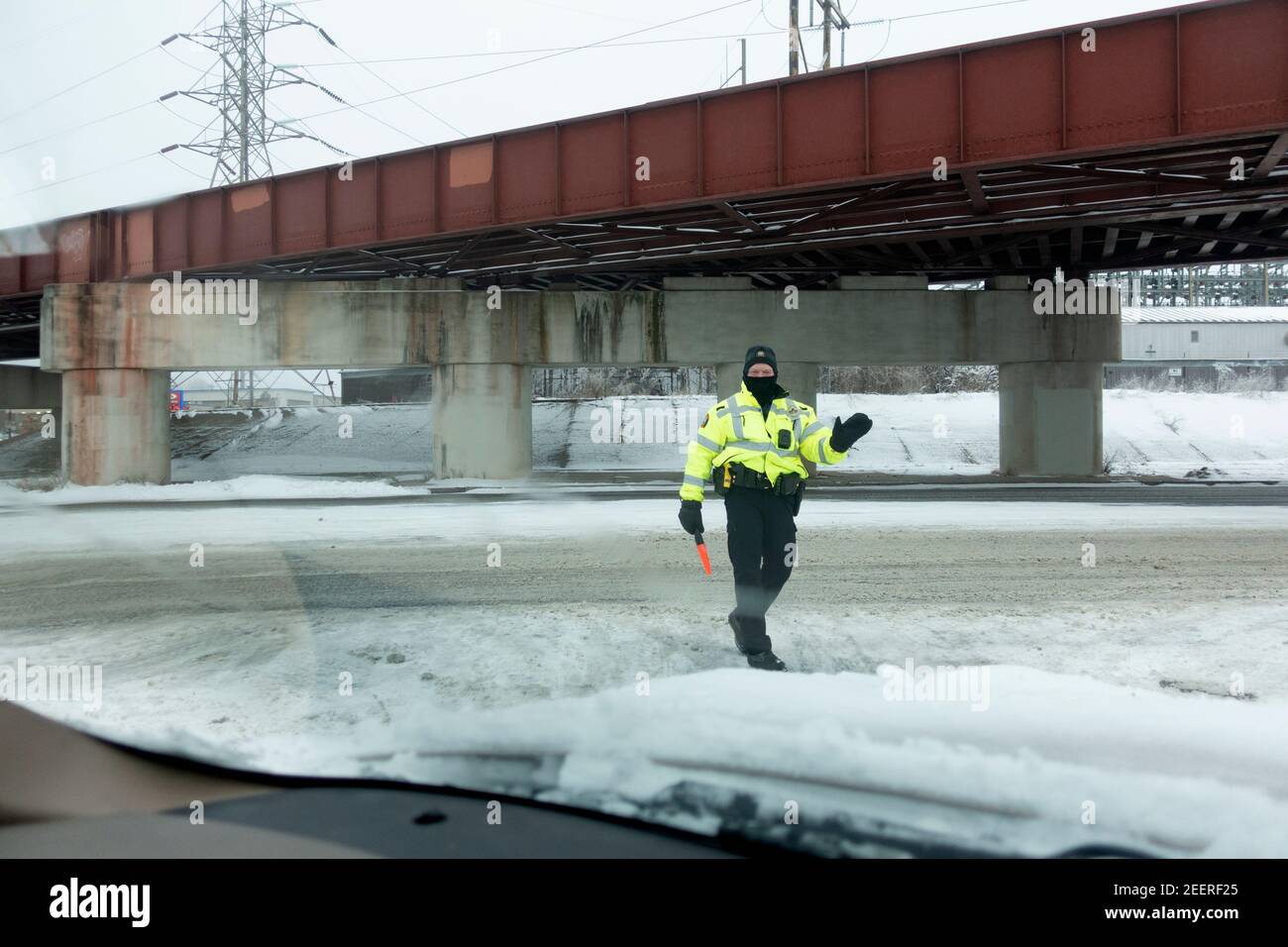 Masked police person directing traffic at the Starbucks drive-thru during the corona Pandemic. St Paul Minnesota MN USA Stock Photo
