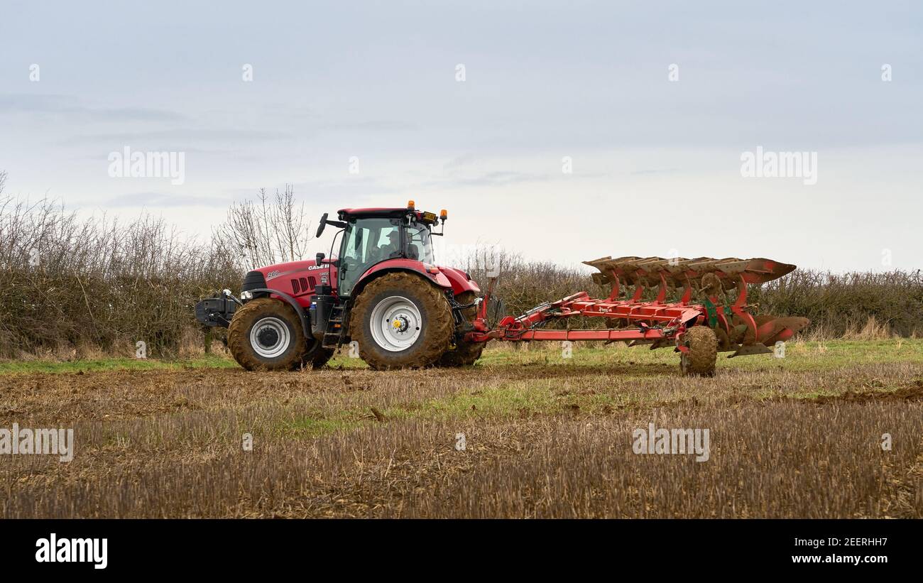 Case puma 200 agricultural tractor turning a six furrow semi mounted plough over at the end of a field Stock Photo