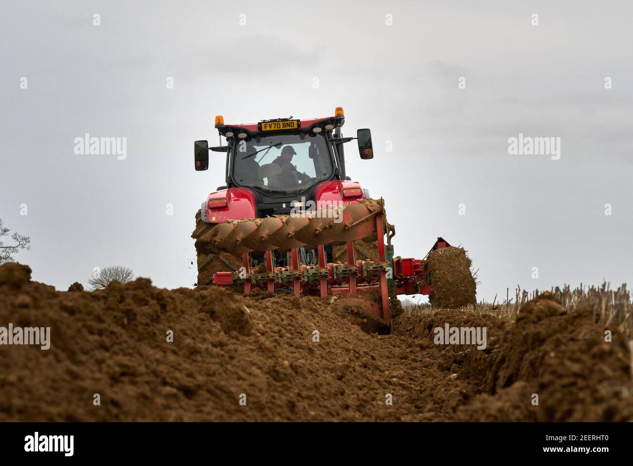 Rear view of Case Puma 200 horsepower tractor ploughing with six furrow semi mounted Kvernland plough Stock Photo