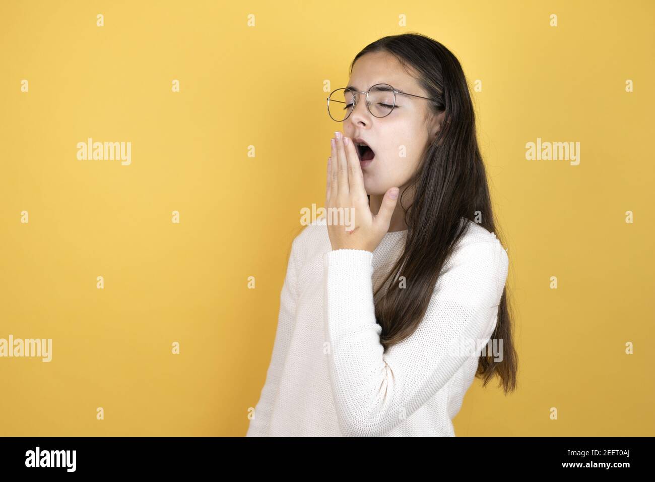Beautiful child girl wearing casual clothes bored yawning tired covering mouth with hand. Restless and sleepiness. Stock Photo