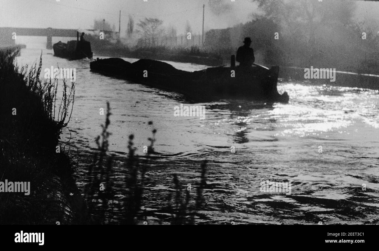Narrowboats transporting coal on a foggy morning along the Tipton Canal in the West Midlands 'Black Country' in 1953 Stock Photo