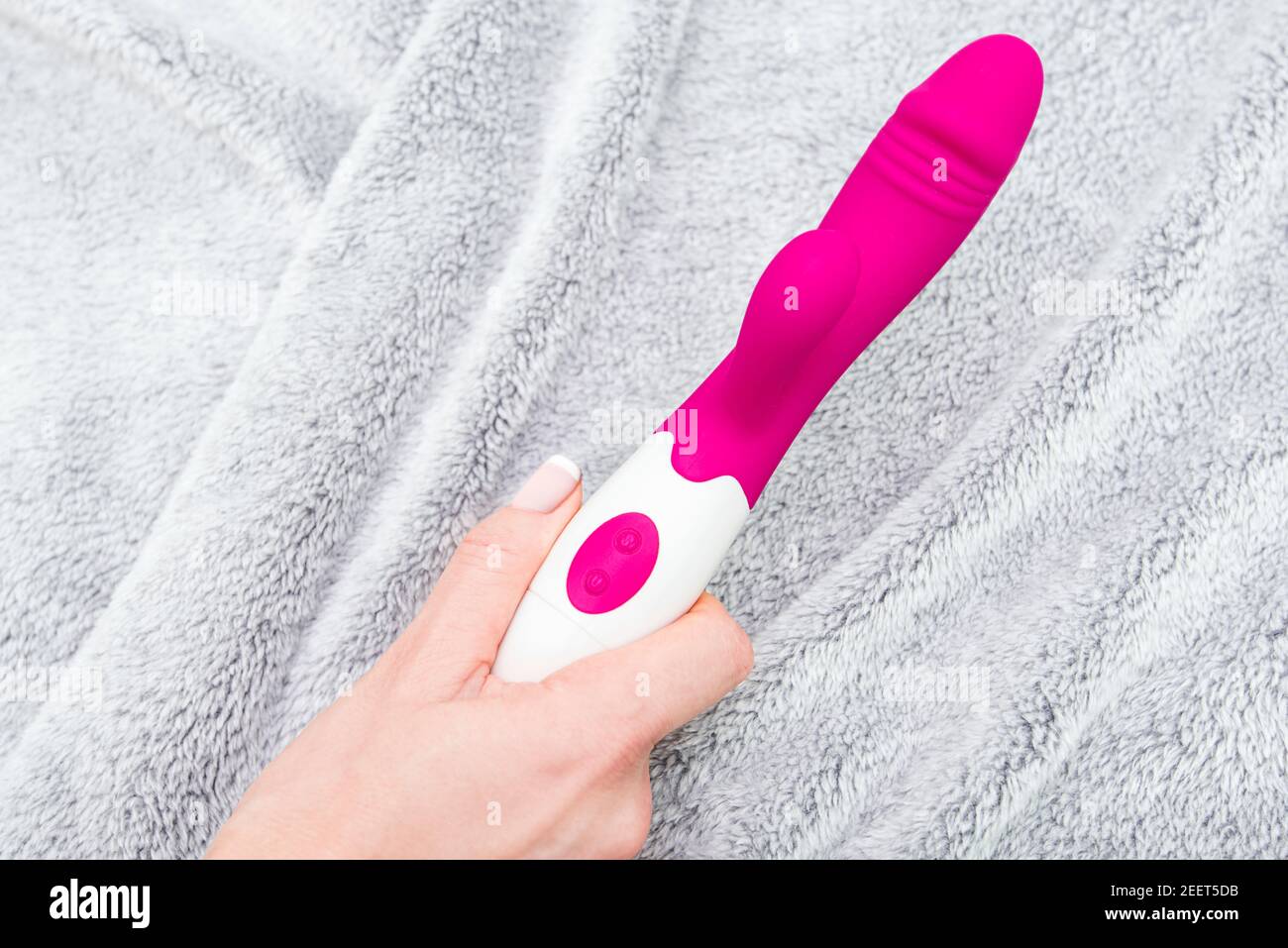 Woman holding adult sex toy, pink dildo or vibrator in the bed Stock Photo  - Alamy