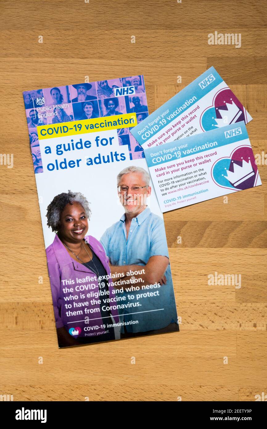 A NHS guide to Covid-19 vaccinations for older adults, with two Covid-19 vaccination record cards. Stock Photo