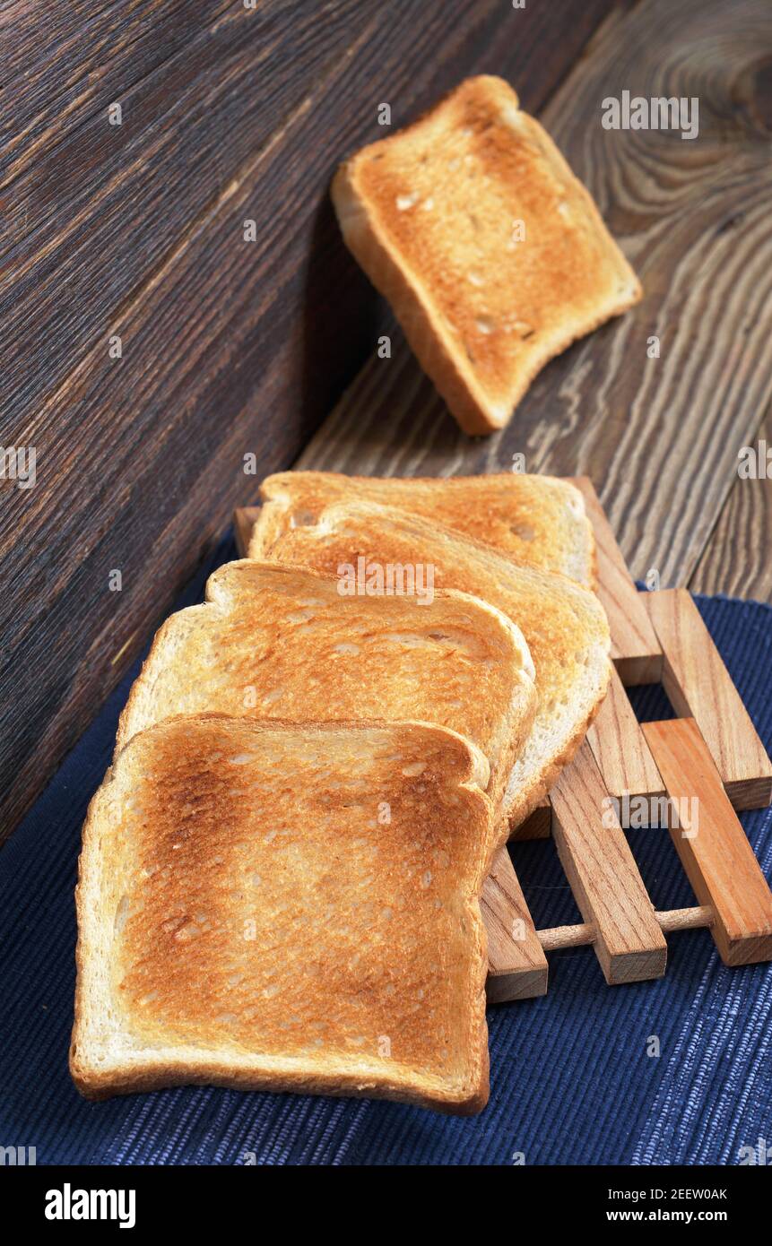 Slices of toasted bread on old wooden table. Vertical composition Stock ...
