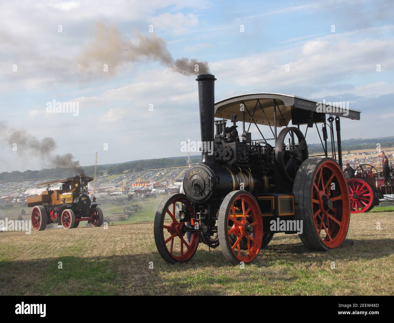 a beautiful scene at the great dorset steam fair with two steam road locomotives driving at a hill at the big festival terrain in summer Stock Photo