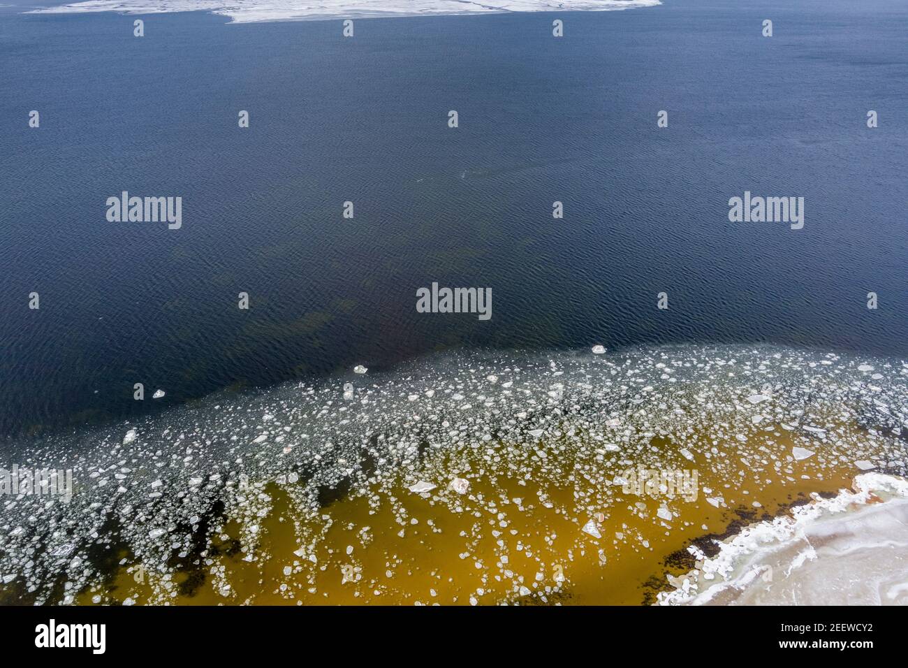Ice blocks drifting around in a calm sea water creating interesting aerial patterns. Stock Photo
