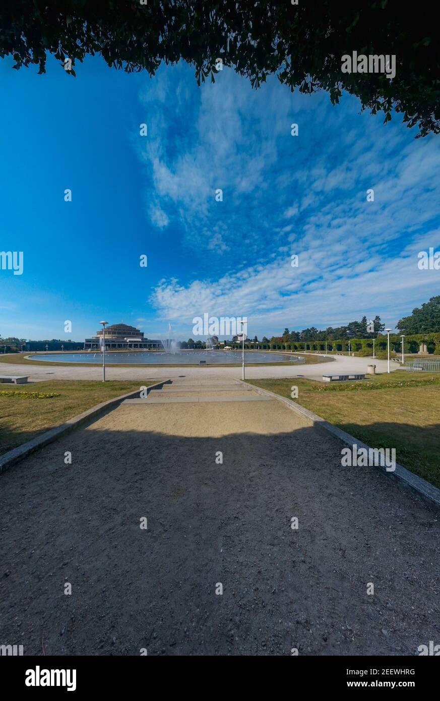 Panorama of Pergola fountain in Wroclaw and stairs path with centennial hall in background and leafs in frame Stock Photo