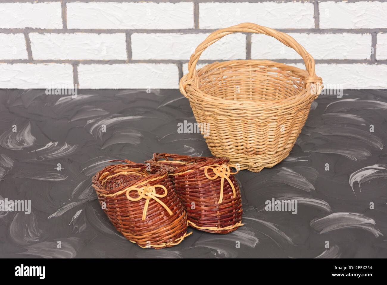 Products wicker made of natural vine. Decorative basket and slippers for home interior. Hand made, selective focus. Stock Photo