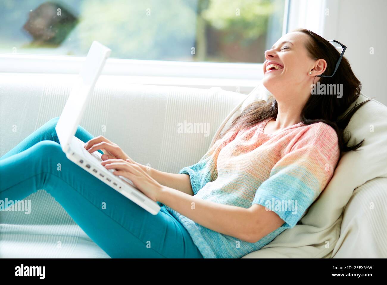 Woman smiling using laptop Stock Photo
