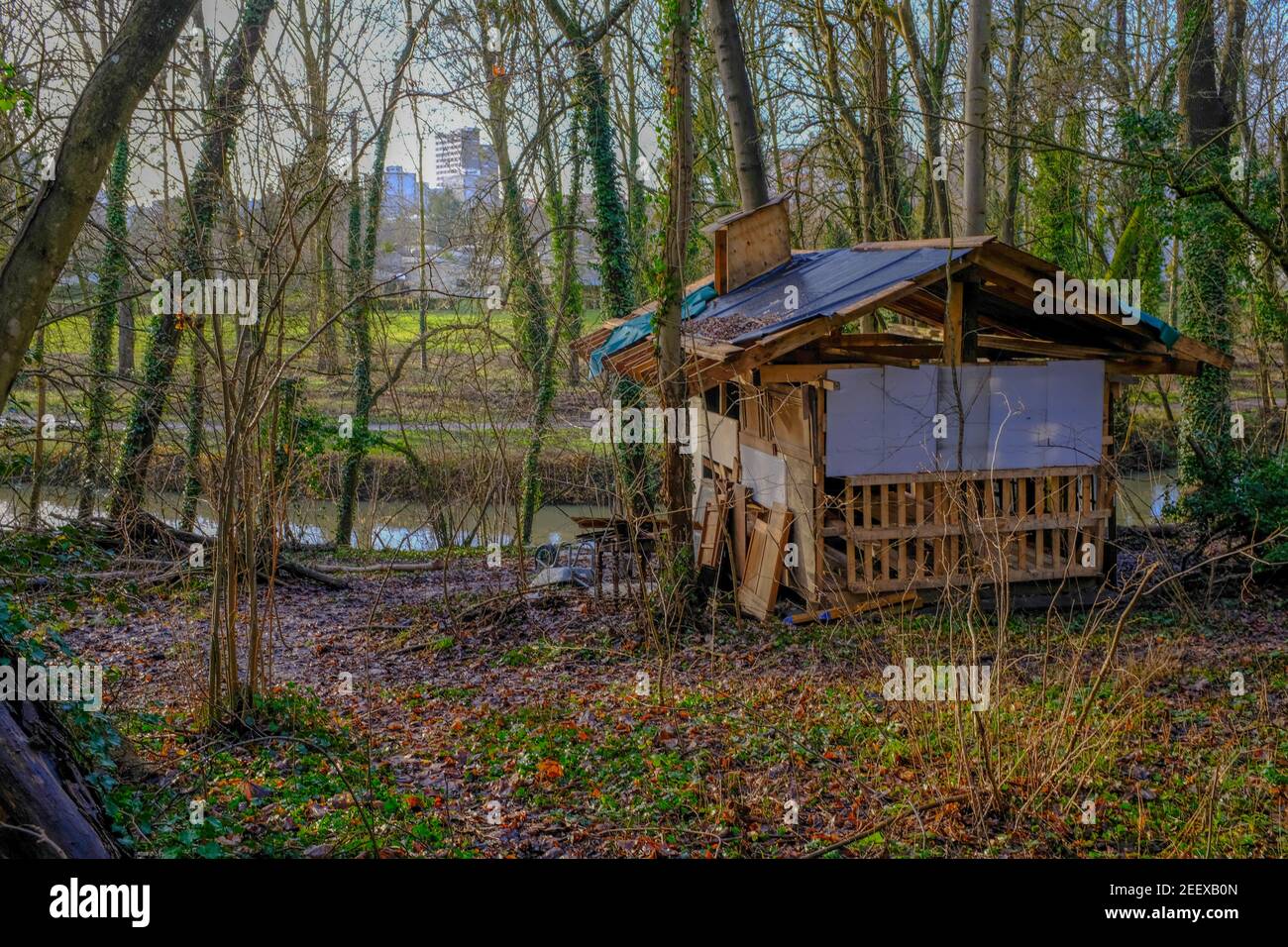 Dilapidated shack on the edge of a small river. Taken on a sunny winter day near Paris, France Stock Photo