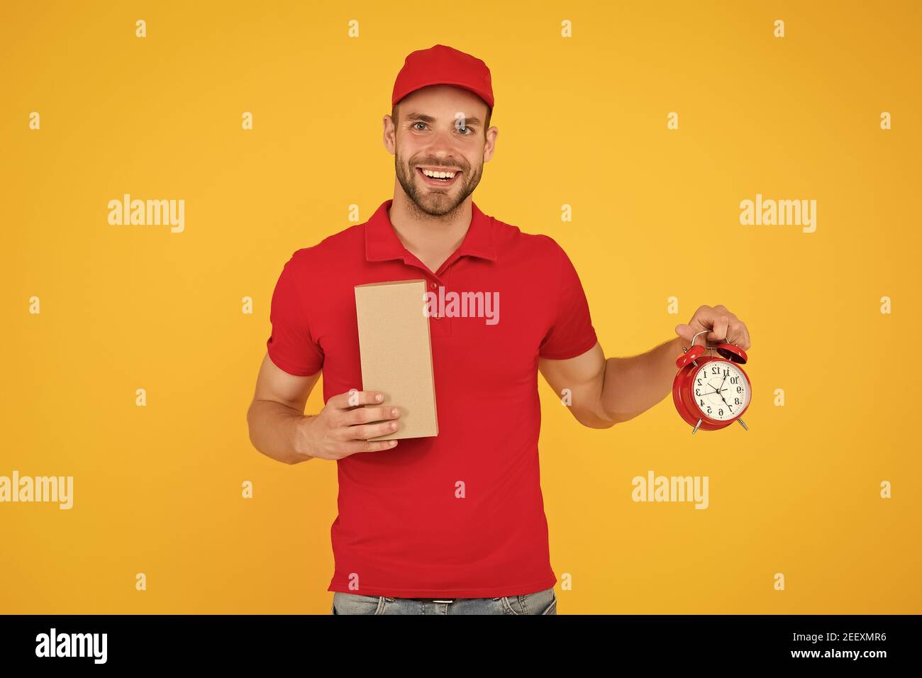 Real joy. go online shopping. Delivery during quarantine. friendly staff man. delivery time. Delivery Courier with time clock holding box. take your parcel. gift delivery man holding vintage clock. Stock Photo