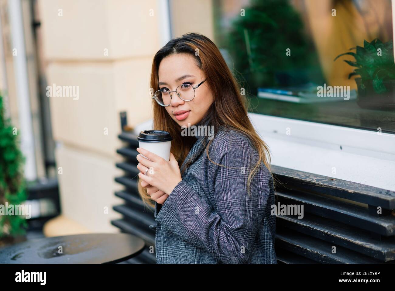 https://c8.alamy.com/comp/2EEXYRP/charming-asian-woman-with-beautiful-smile-reading-good-news-on-mobile-phone-during-rest-in-coffee-shop-happy-female-watching-her-photos-on-cell-telep-2EEXYRP.jpg