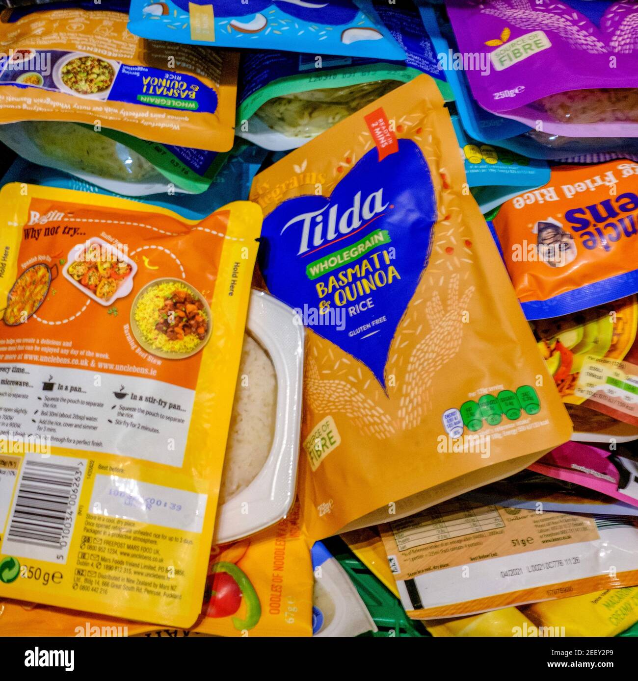 Crate of microwaveable packets of rice as part of dried food donations donated to a Trussell Trust foodbank. Microwave rice in plastic packaging. Stock Photo