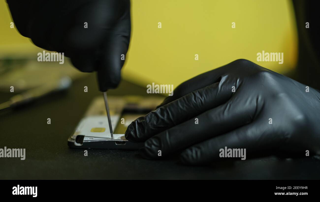 Technician man hands while working on smartphone repair,hi tech device service Stock Photo