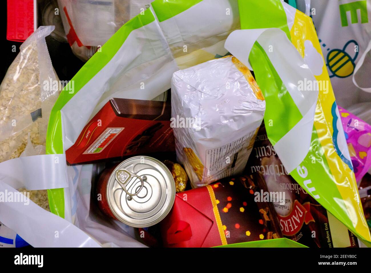 A shopping bag full of chocolate, biscuits and crackers donated to a foodbank in London. Stock Photo