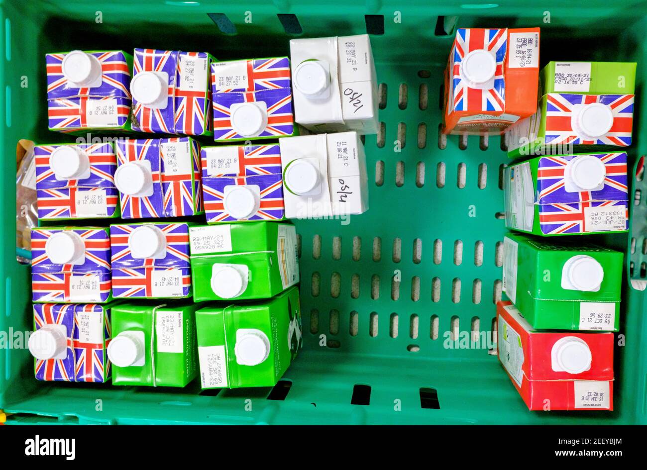 Cartons of British UHT cow milk in a crate donated to a Trussell Trust foodbank. London, UK. Union Jack on top of the carton packaging. Stock Photo