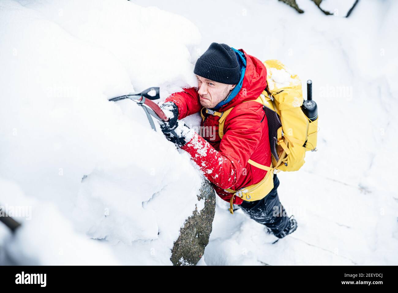 Winter rock climbing. Handsome mountaineer with an ice ax Stock Photo Alamy
