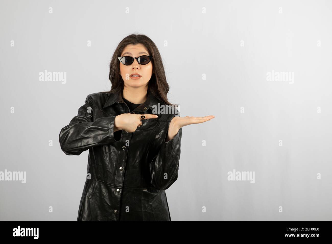 Image of a young woman in black coat wearing glasses and posing Stock ...