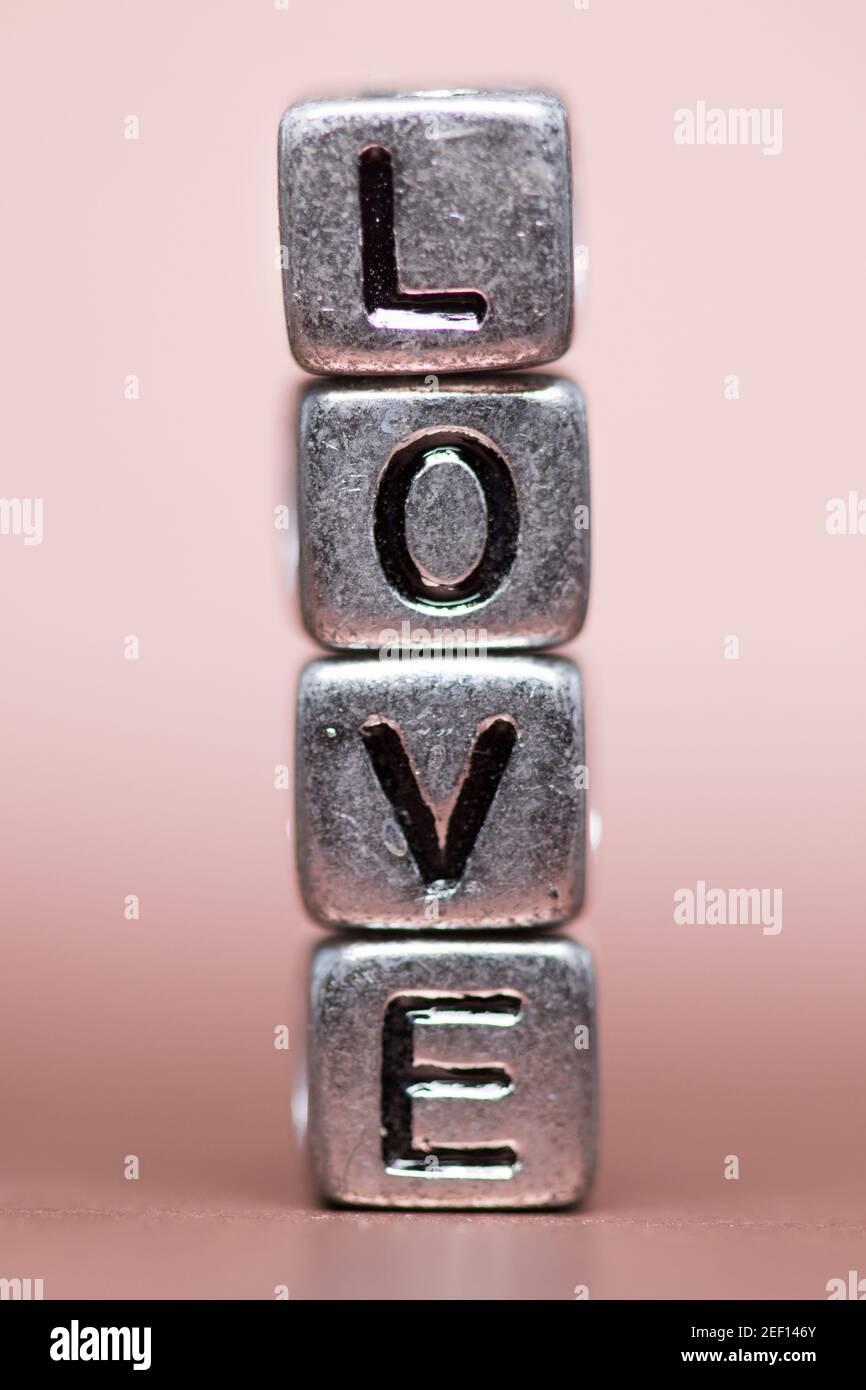 Close up of metalic cubed beads spelling the word love Stock Photo
