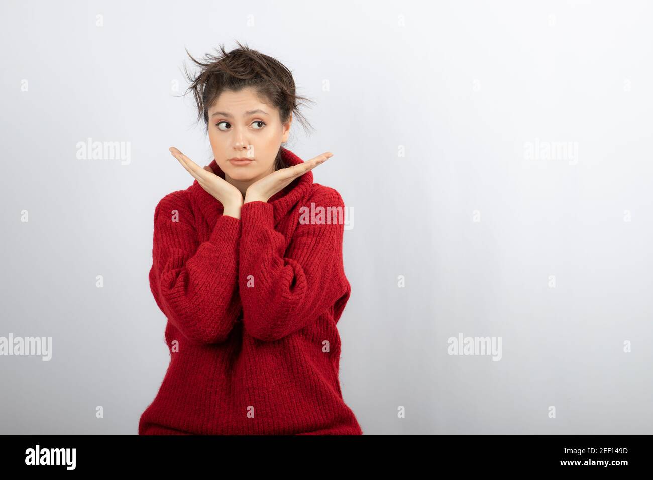 Photo of a pretty female model keeping hands under chin Stock Photo