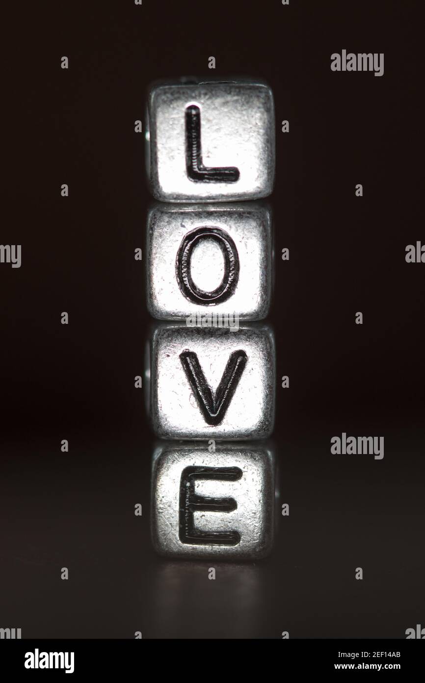 Close up of metalic cubed beads spelling the word love Stock Photo