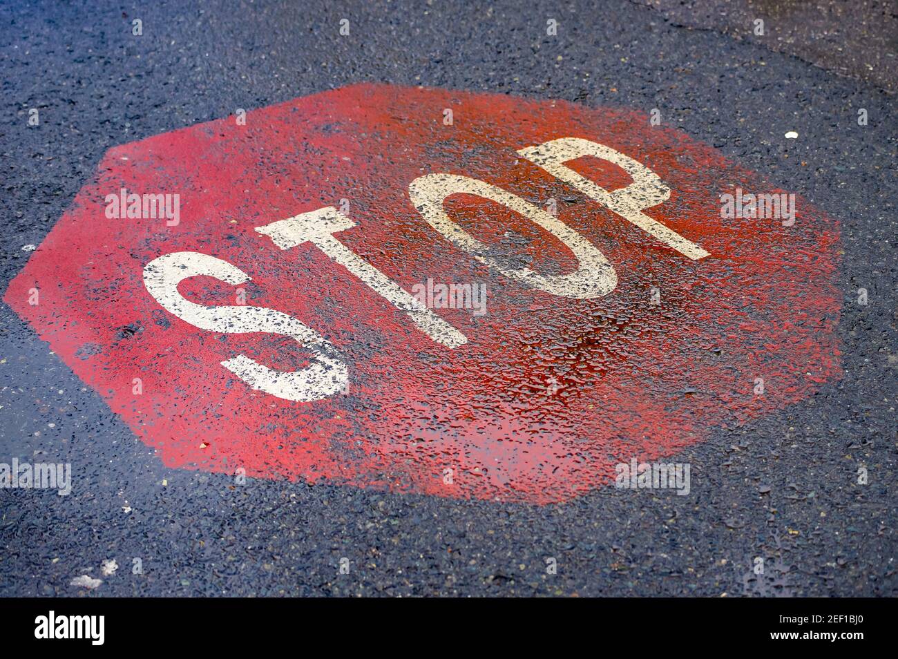 Bucharest, Romania - January 25, 2021: A stop sign painted on asphalt at the intersection of a road in Bucharest. Stock Photo