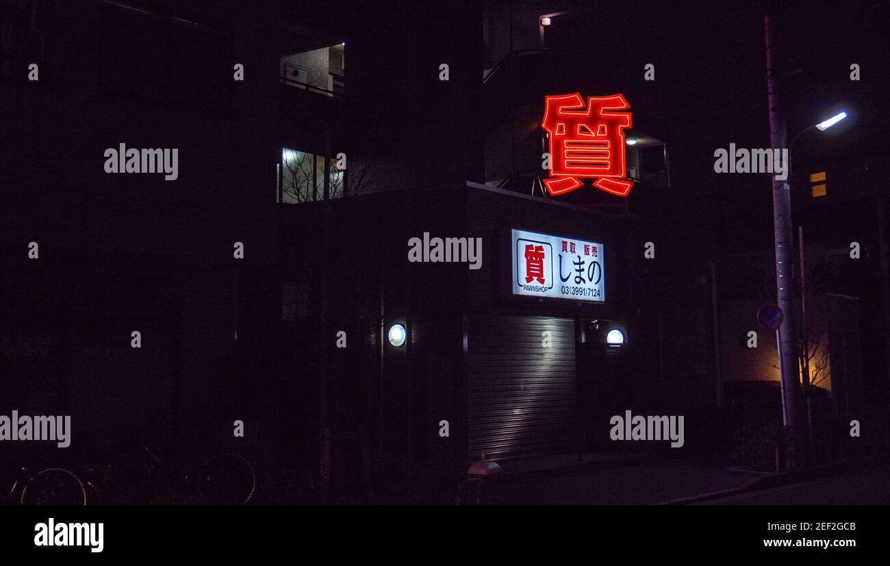 The red neon sign of a Tokyo pawn shop at night. Stock Photo