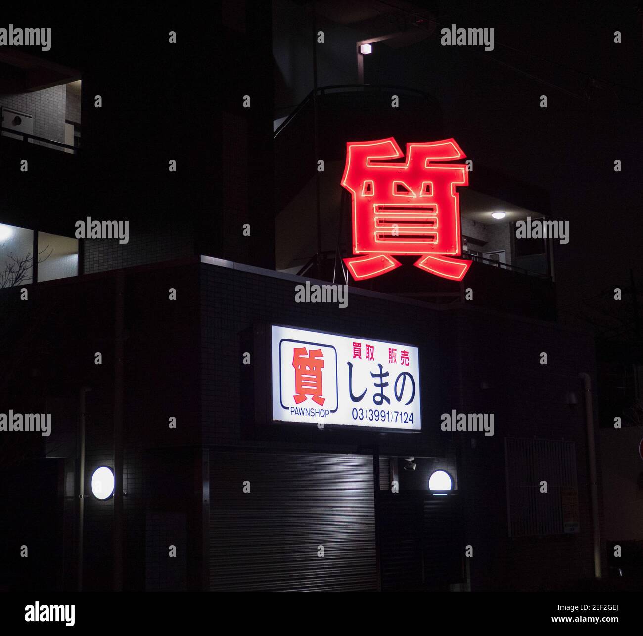 The red neon sign of a Tokyo pawn shop at night. Stock Photo