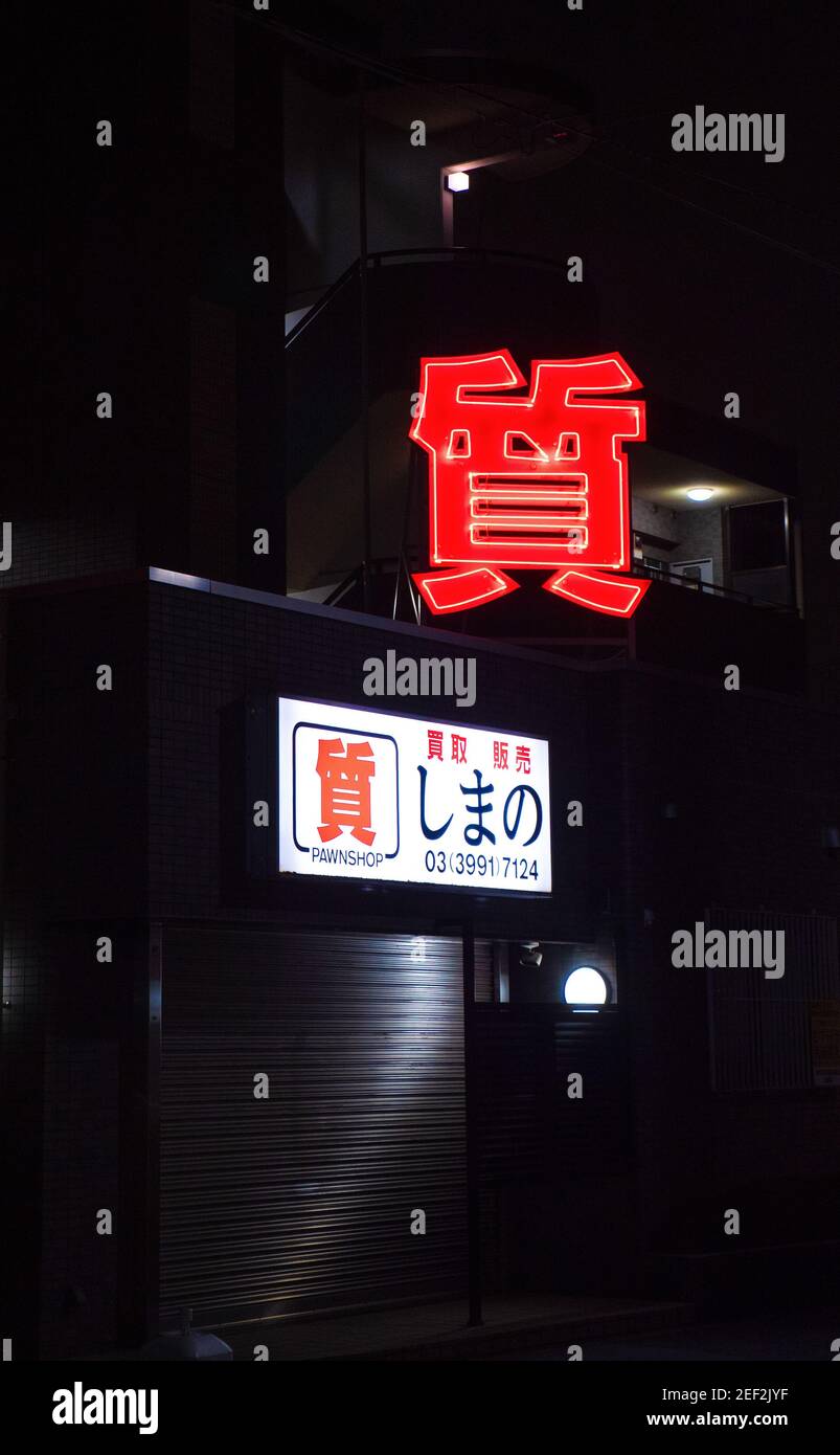 The red neon sign of a Tokyo pawn shop at night. Stock Photo