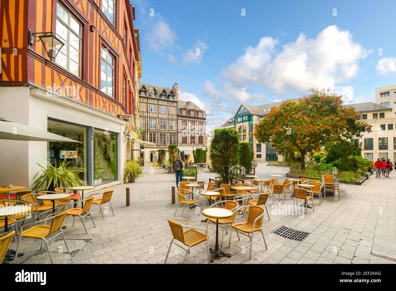 Timber frame homes line a town square in the medieval city of Rouen France with shops, a sidewalk cafe and tourists enjoying a sunny autumn day Stock Photo