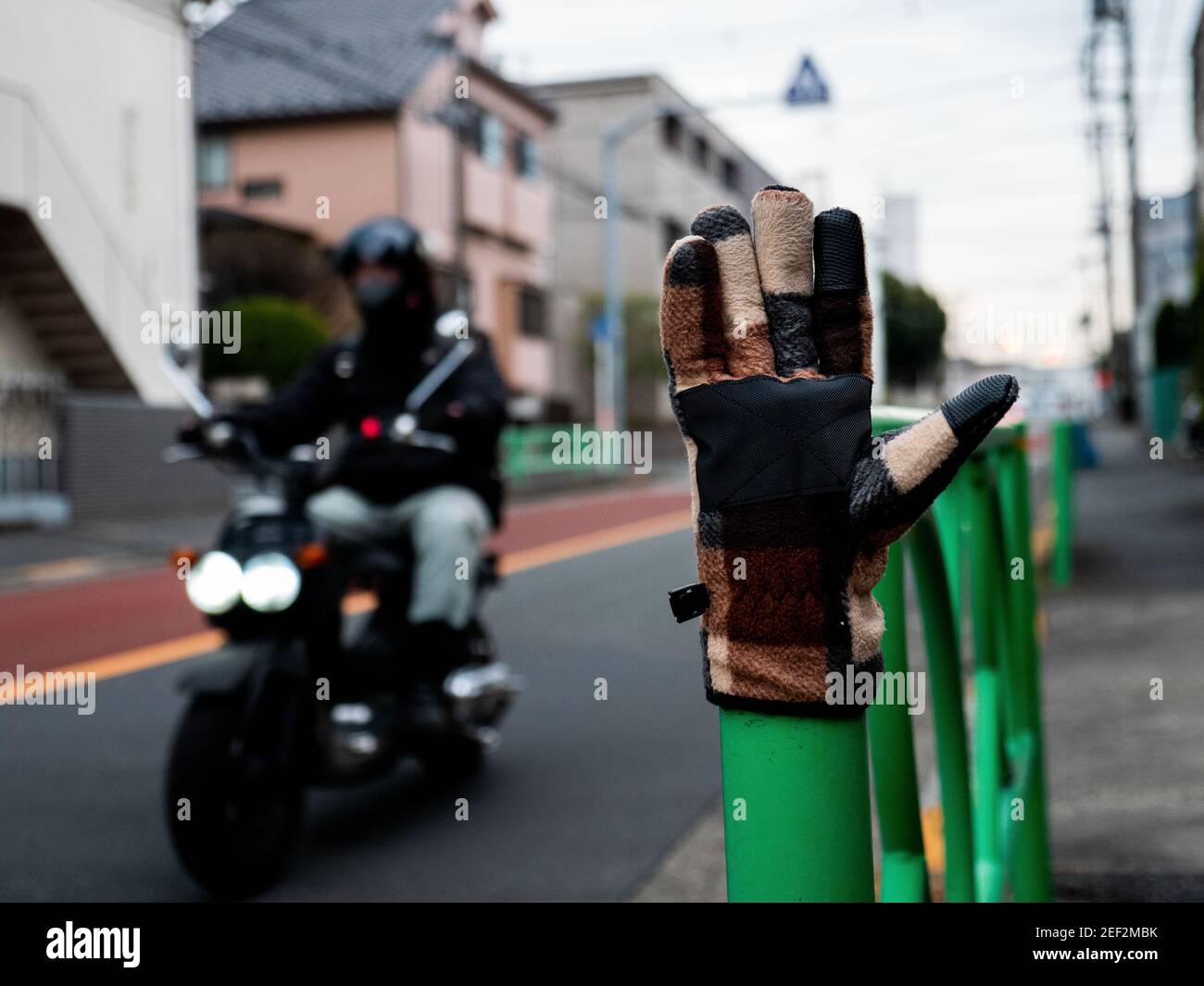 A glove sits on a post next to a busy road in Tokyo, Japan. Stock Photo
