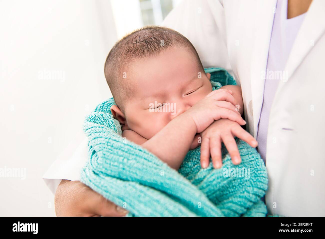 Doctor holding sleeping newborn baby in the arms Stock Photo