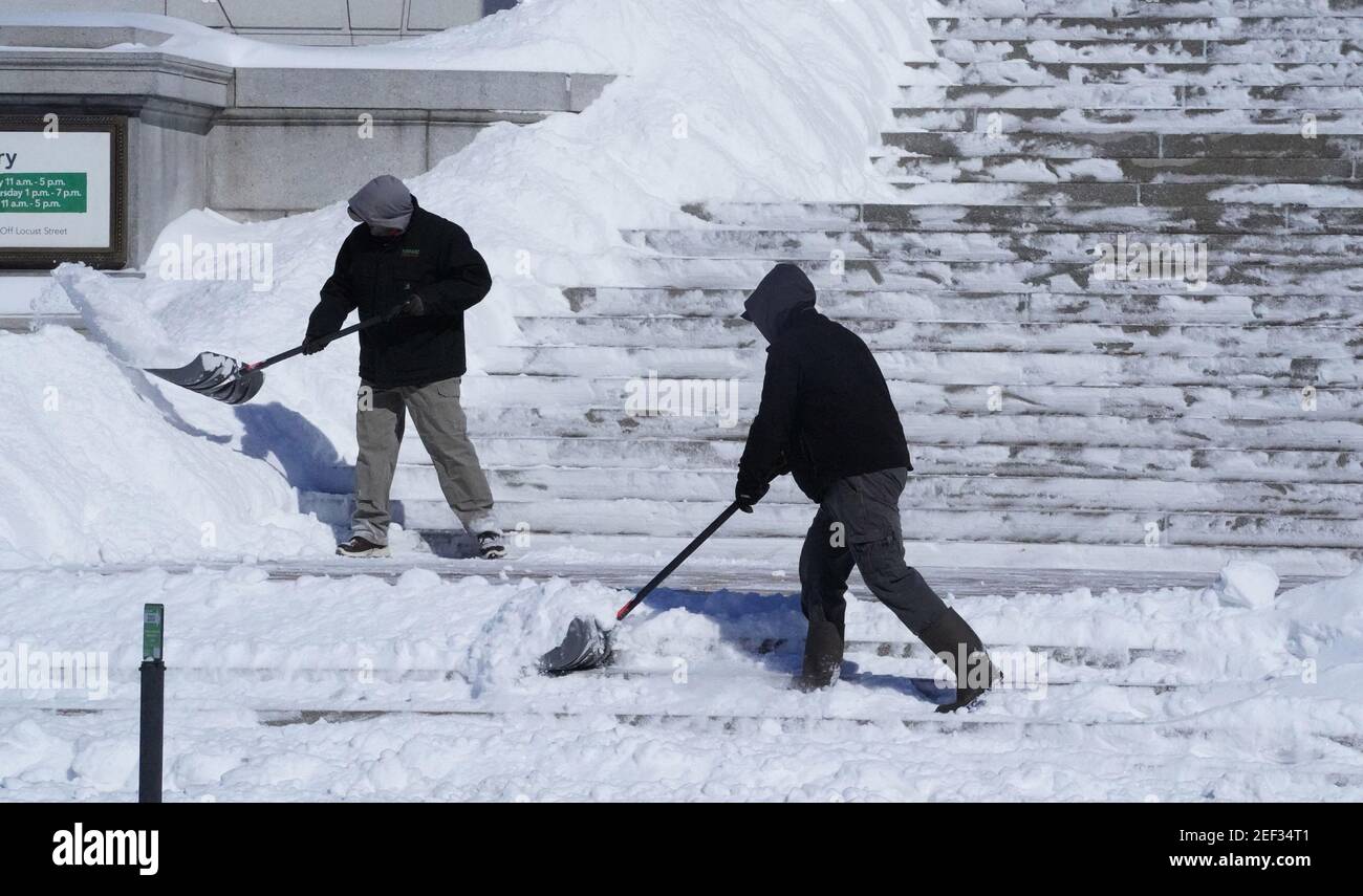 St. Louis, United States. 16th Feb, 2021. Men clear 8 inches of snow from the main stairway of the St. Louis library in downtown St. Louis on Tuesday, February 16, 2021. Photo by Bill Greenblatt/UPI Credit: UPI/Alamy Live News Stock Photo