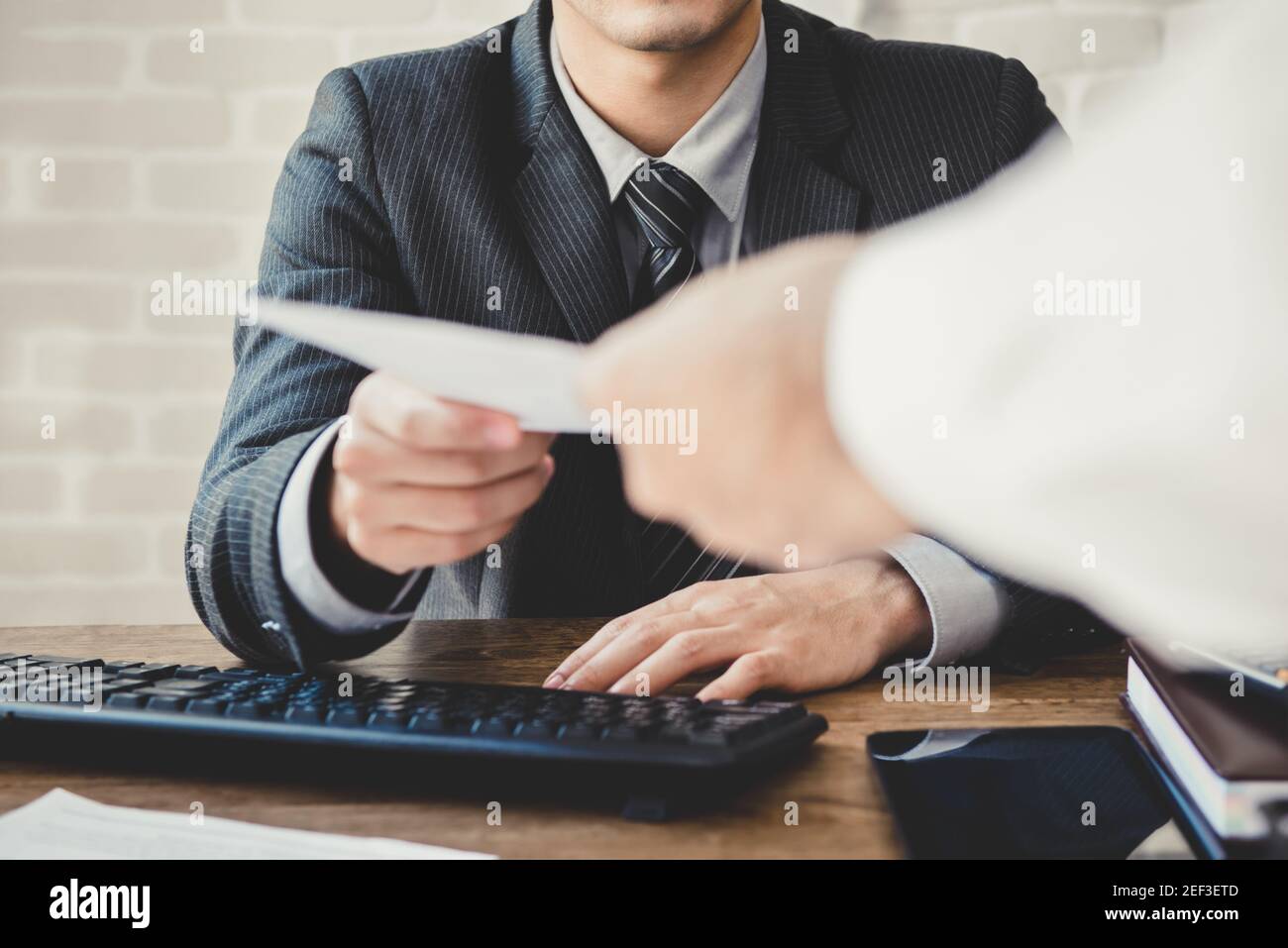 Businessman passing document to manager at the office Stock Photo