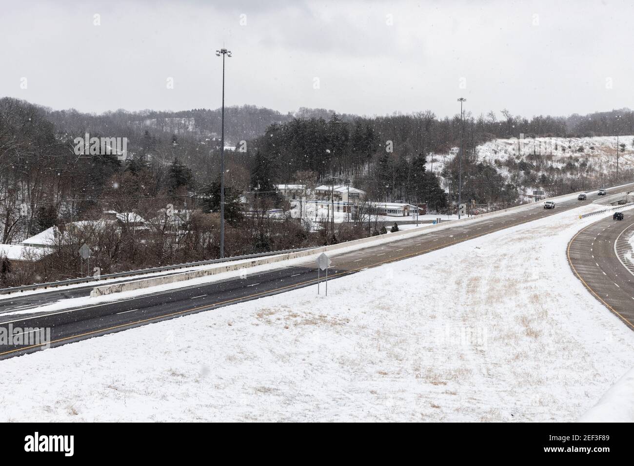 A view of a highway and countryside of Appalachia is covered with snow.Snowstorm Uri swept across the United States from February 12th to the 16th covering the United States in snow and Ice. Uri begun in the Pacific Northwest, and headed all the way to the southeast of US. The storm has claimed many lives due to car accidents and low temperatures. In Athens County Ohio the storm began on Monday morning February 15, 2021 and has continued into Tuesday 16, 2021. Currently Athens County is under a level two snow emergency. Stock Photo