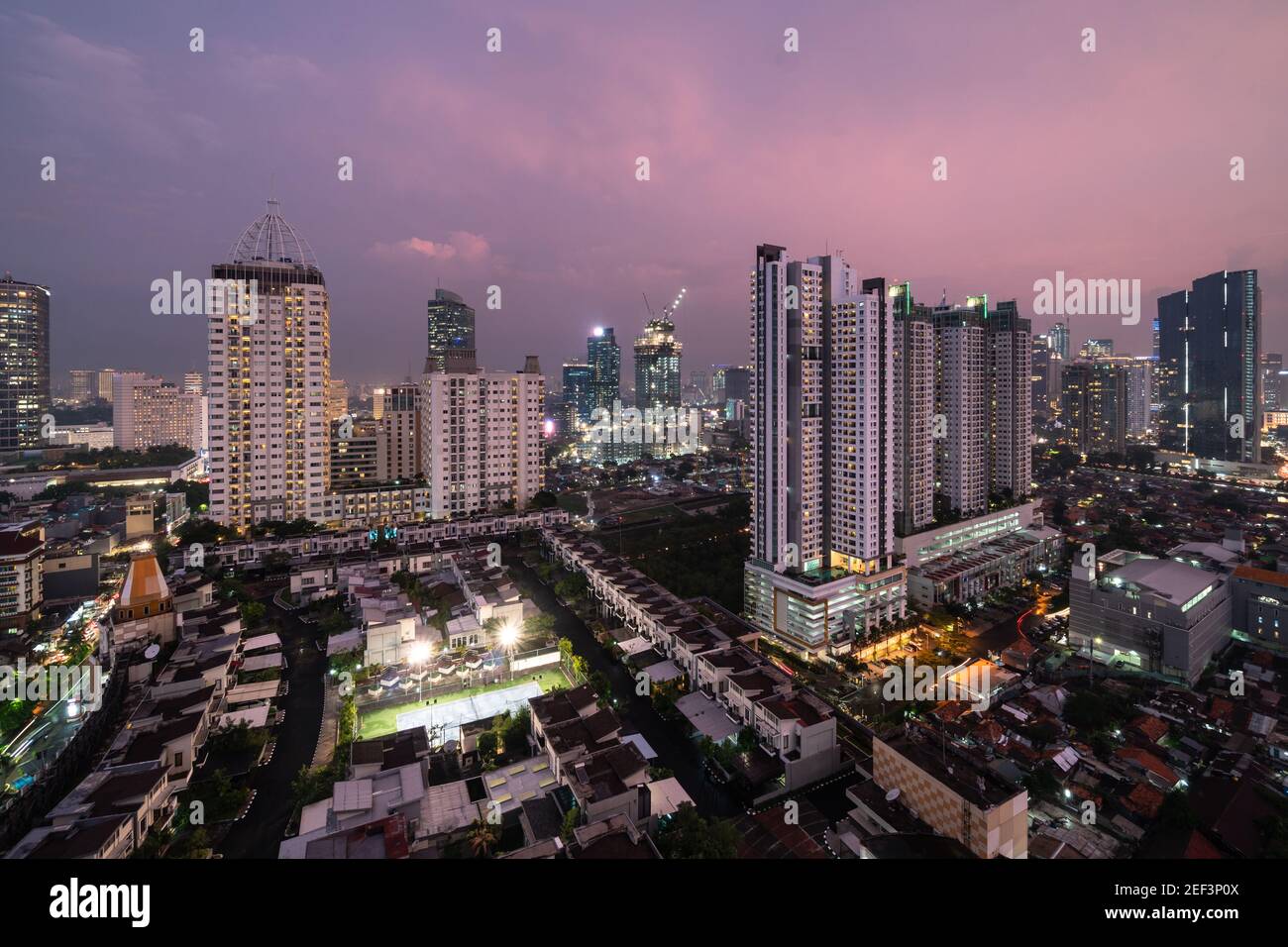 Sunset over Jakarta skyline where residential towers and houses