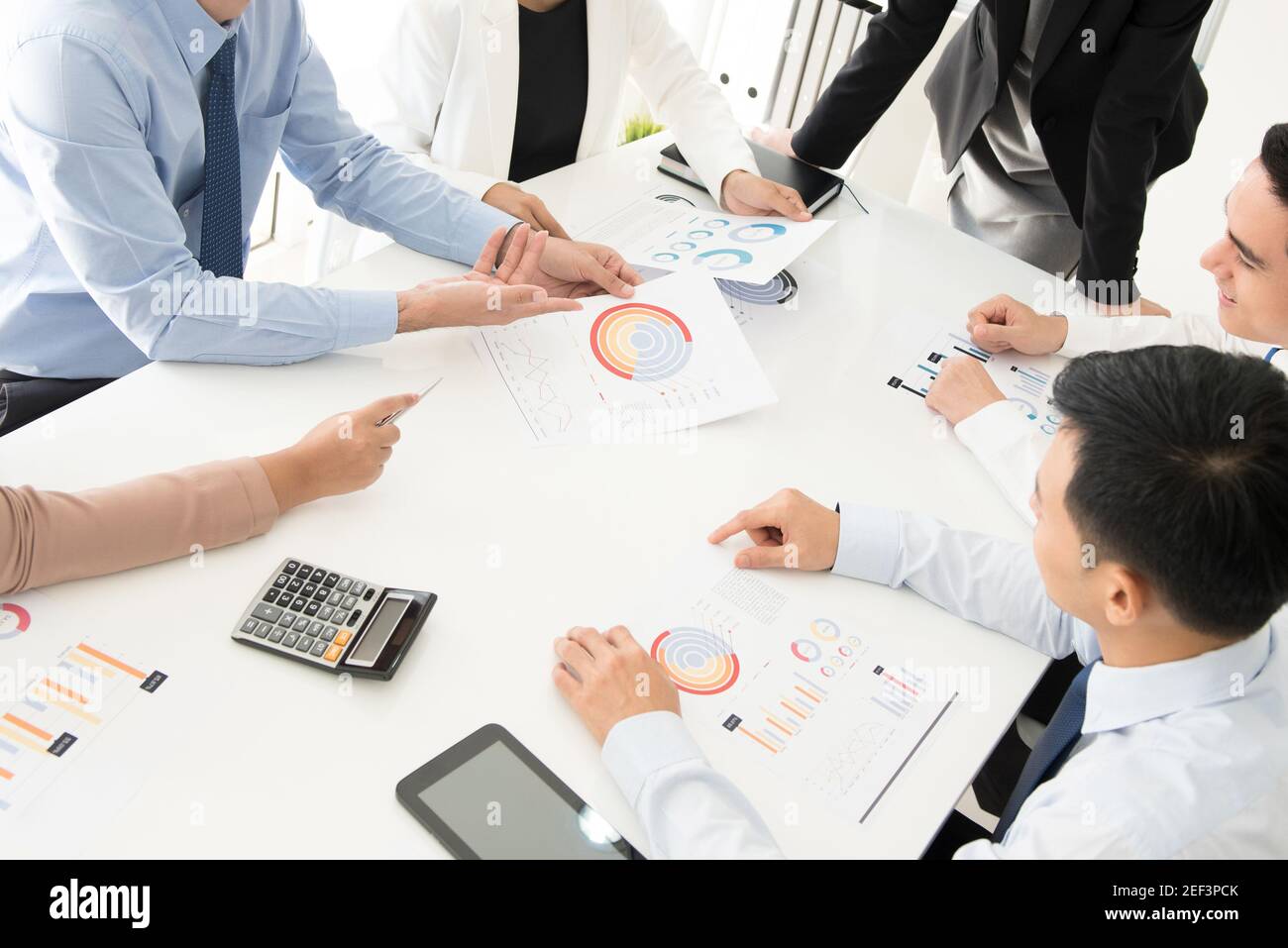 Business people discussing documents at meeting table Stock Photo - Alamy