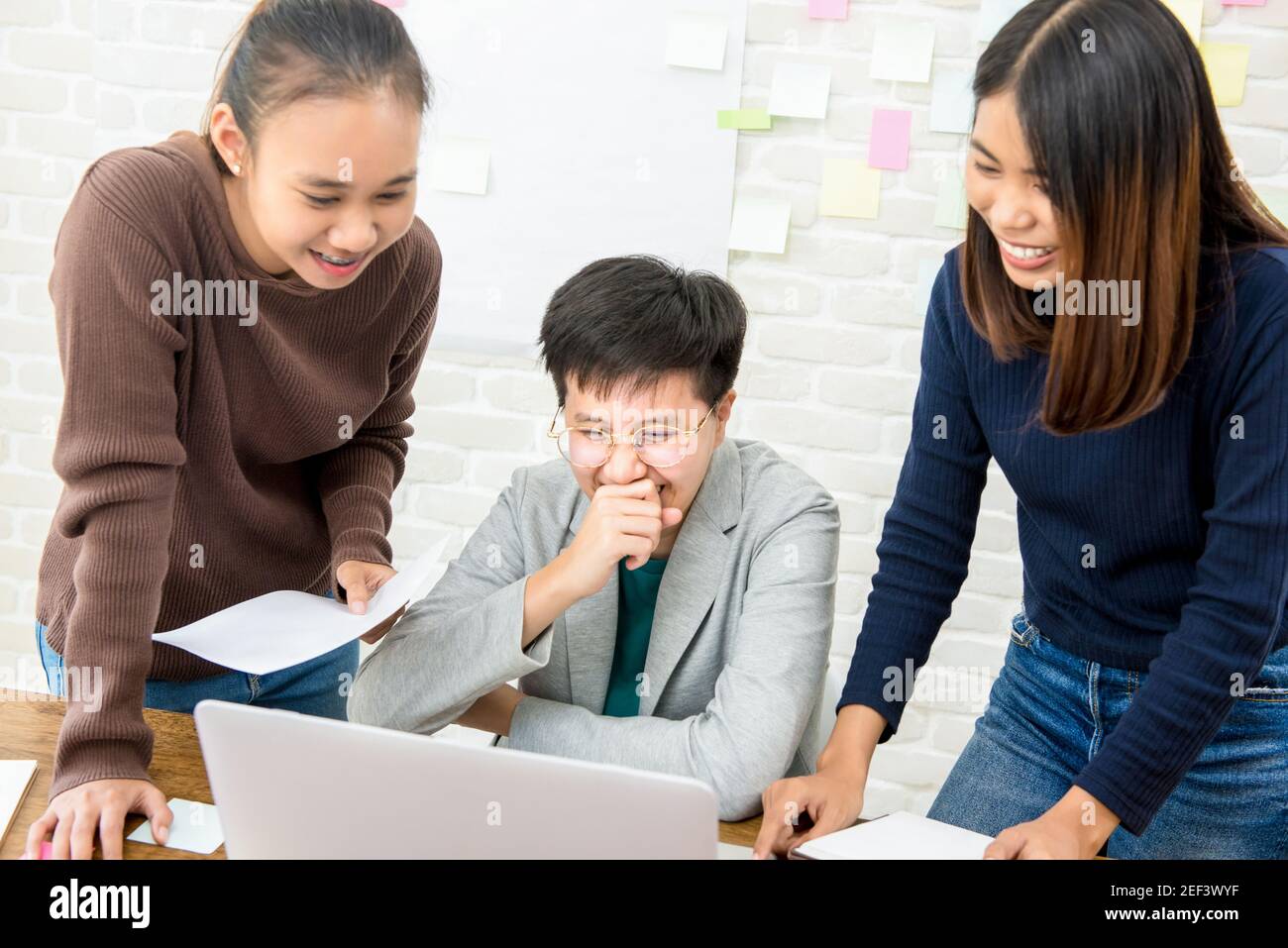 College students having fun, looking at laptop coomputer - multimedia learning concept Stock Photo