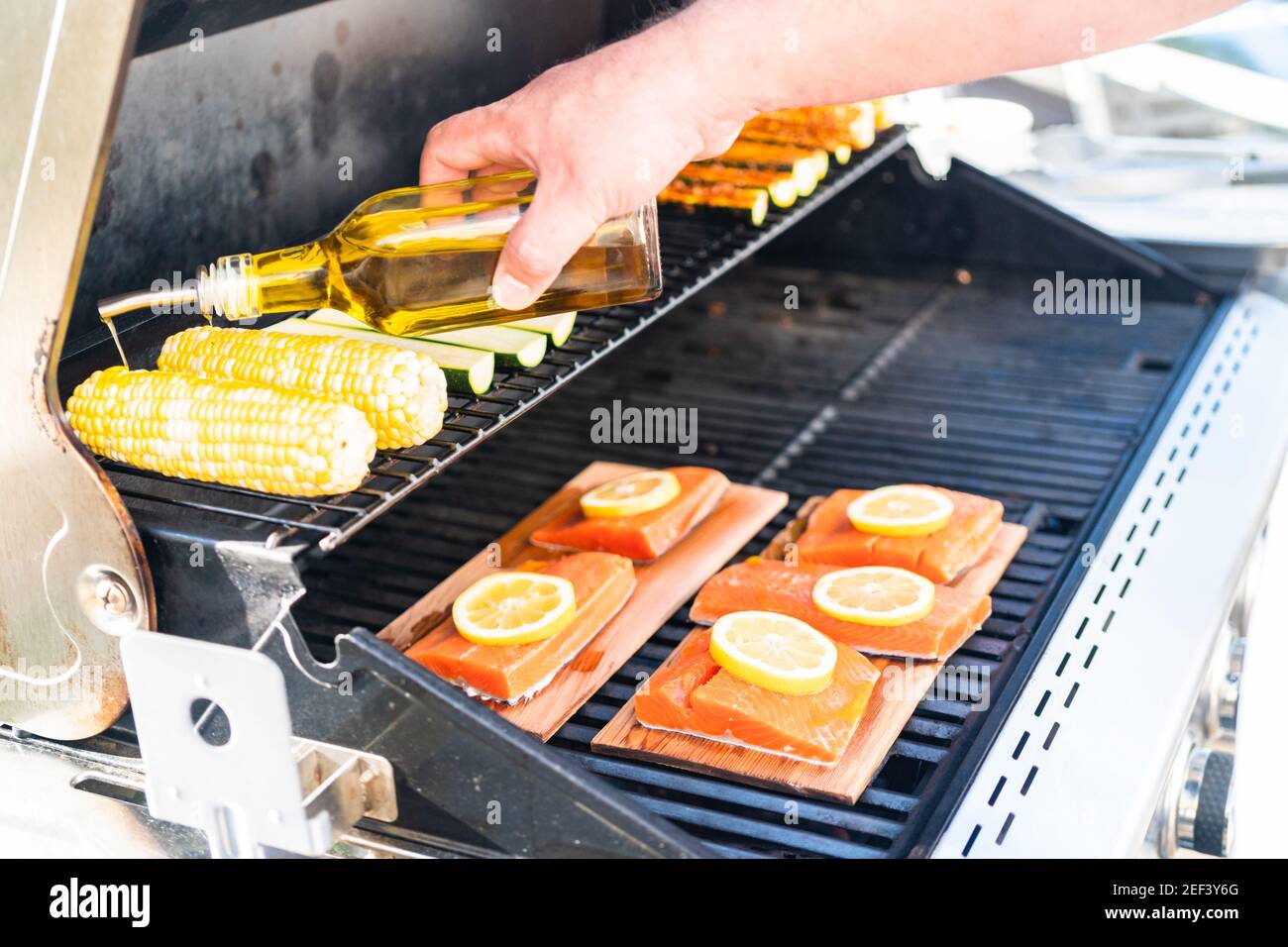 Grilling salmon on a gas burning grill on the backyard patio Stock