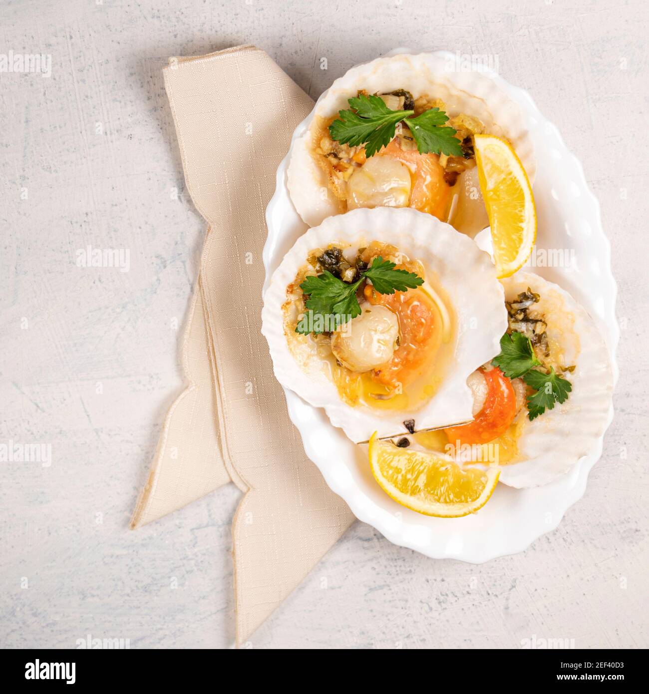 Baked scallops with caviar and creamy garlic sauce in white plate