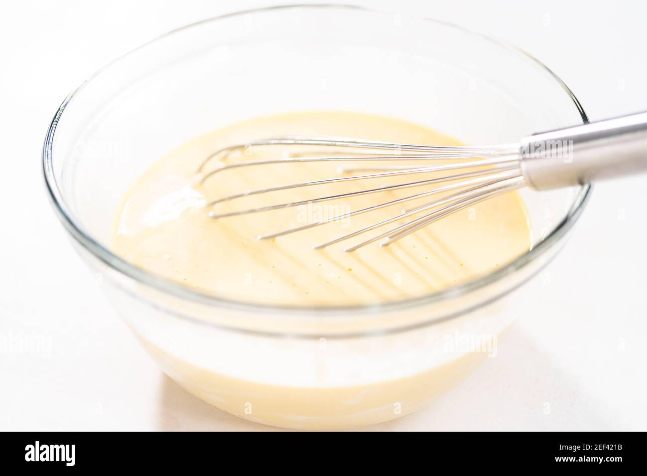Mixing ingredients in a glass mixing bowl to bake chocolate bundt cake