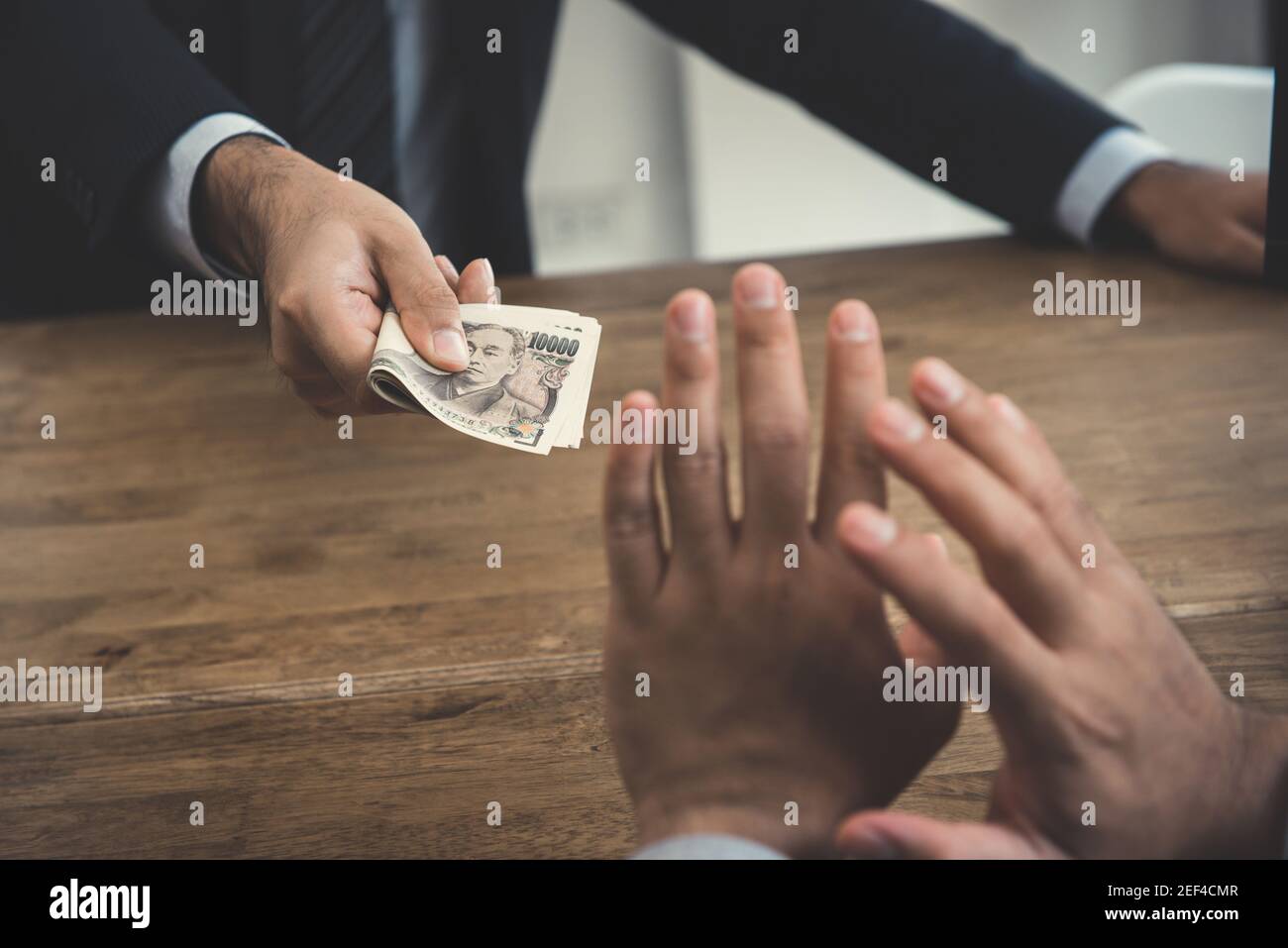 A man refusing money, Japanese yen, from a busisnessman - anti bribery and corruption concepts Stock Photo