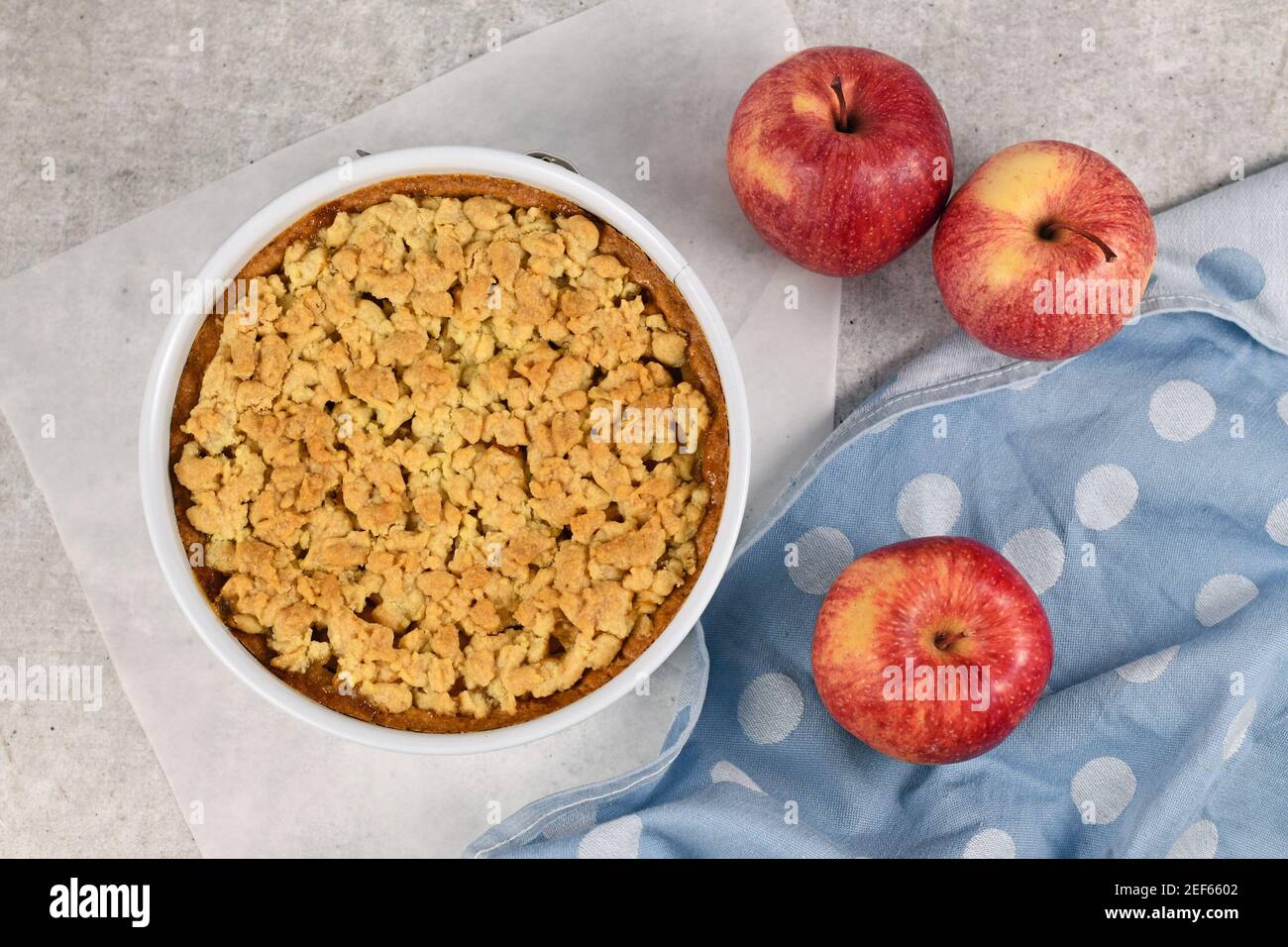 Whole traditional European apple pie with topping crumbles in white